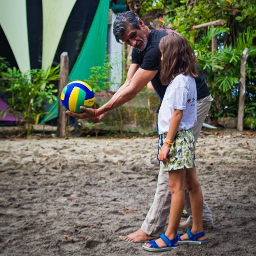 man teaching girl how to serve vollleyball