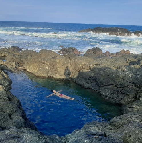 Woman floating in the tide pool at Amor De Mar, Montezuma Costa Rica